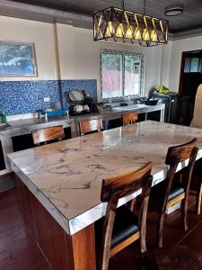 a kitchen with a large marble table and chairs at Brandons Beach Resort in Inayauan