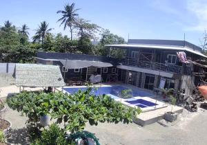 a house with a swimming pool in front of it at Brandons Beach Resort in Inayauan