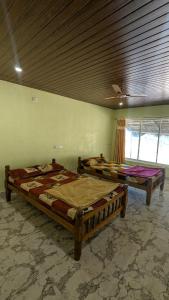 two beds sitting in a room with a ceiling at Coco Beach Front Stay & Cafe in Gokarna +12 photos