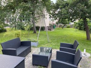 a patio with two chairs and a table and a swing at Ferienwohnung Lahann in Saalfeld +9 photos