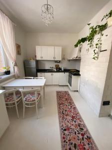 a kitchen with a table and two chairs and a rug at Królewska Sielanka in Mielnik