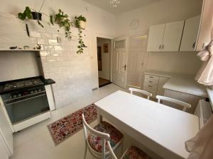 a kitchen with white cabinets and a table with chairs at Królewska Sielanka in Mielnik +46 photos