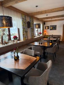 a restaurant with tables and chairs in a room at Pension Trojerhof in Heiligenblut