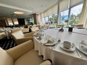 a dining room with white tables and chairs at Hotel Business Faltom Gdynia in Gdynia