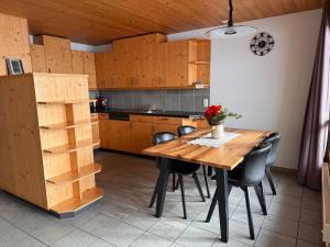a kitchen with a wooden table and chairs at Ferienwohnung Leuweli in Hasliberg +21 photos