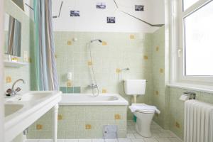 a bathroom with a tub and a toilet and a sink at Kurhotel & Hotel Mozart in Bad Gastein
