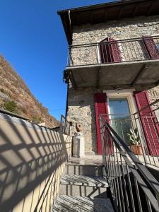 a building with red doors and stairs and a window at La Piazzetta in Sondrio +11 photos