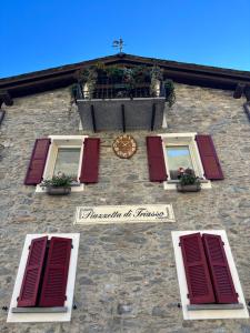 a building with windows and a clock on it at La Piazzetta in Sondrio
