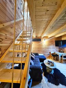 a living room with a staircase in a house at Apartments Homeland in Kolašin