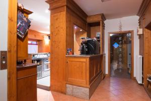 a kitchen with wooden walls and a counter with a refrigerator at Meublè Blue House in Auronzo di Cadore +13 photos