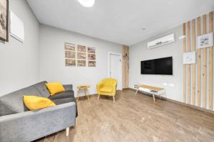 a living room with a couch and a tv at Engel apartments -אירוח למטיילים בגליל עליון in Tsiv'on