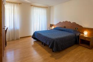 a bedroom with a bed with a blue comforter at Meublè Blue House in Auronzo di Cadore