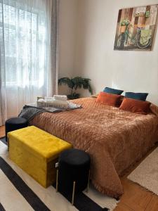 a bedroom with a large bed with orange and blue pillows at Thomas Suite Calheta in Lombada dos Marinheiros