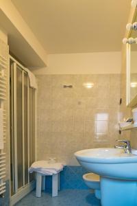 a bathroom with a sink and a tub and a toilet at Meublè Blue House in Auronzo di Cadore