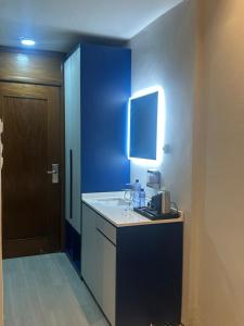 a kitchen with a counter and a blue wall at La Mariette Hôtel & Resort in Kisantu
