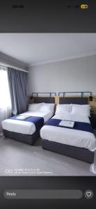 two beds sitting next to each other in a bedroom at La Mariette Hôtel & Resort in Kisantu