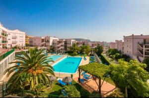 a view of a swimming pool with palm trees and buildings at Casa Da luz 5 - sea view 2 bedrooms apt , beach & swimming-pool in Luz