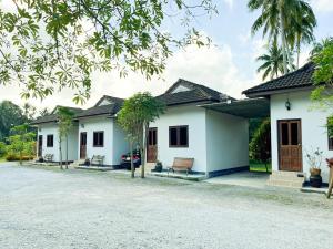 a white house with benches in front of it at ลียา รีสอร์ท in Ban Bang Mak (1)