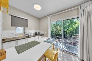 a kitchen with a table and a large window at Engel apartments -אירוח למטיילים בגליל עליון in Tsiv'on