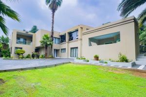 a house with a palm tree in front of it at The Hide on Aston-Sandton in Johannesburg