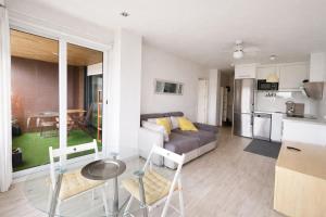 a living room with a couch and a table and chairs at Apart CityMar 24h Terraza y vistas Ria Vigo in Vigo