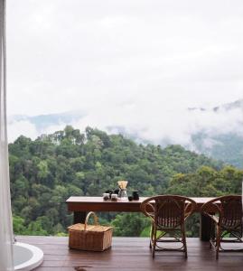 a table with chairs and a view of a mountain at Thammachart The Nature in Ban Kai Noi