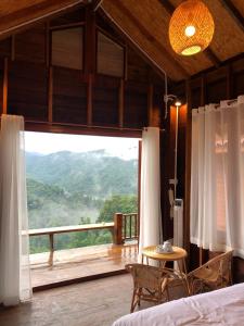 a bedroom with a large window with a view at Thammachart The Nature in Ban Kai Noi +6 photos