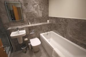 a bathroom with a sink and a tub and a toilet at The Malvern Hills Hotel in Great Malvern