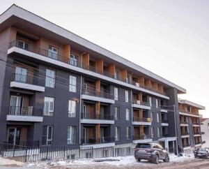 an apartment building with a truck parked in front of it at Bakuriani Cozy Studio in Bakuriani
