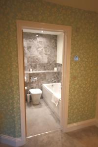 a bathroom with a bath tub and a toilet at The Malvern Hills Hotel in Great Malvern