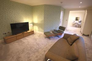 a living room with a couch and a flat screen tv at The Malvern Hills Hotel in Great Malvern