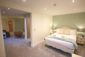 a bedroom with a bed and a living room at The Malvern Hills Hotel in Great Malvern