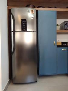 a stainless steel refrigerator in a kitchen with a blue door at Casa em local tranquilo - Bairro Recanto dos Pássaros in Cuiabá