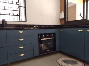 a blue kitchen with a sink and an oven at Casa em local tranquilo - Bairro Recanto dos Pássaros in Cuiabá