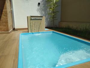 a large blue swimming pool with a water fountain at Casa em local tranquilo - Bairro Recanto dos Pássaros in Cuiabá