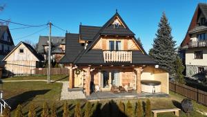 a house with a black roof at Gromada Chalet in Zakopane