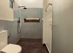 a small bathroom with a toilet and a shower at LaRoy -Mirissa in Mirissa +64 photos