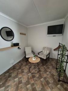 a living room with a table and two chairs and a tv at @Echeveria in Montagu
