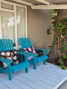 two blue chairs sitting on a porch at @Echeveria in Montagu
