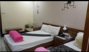 a bedroom with a bed with a pink pillow on it at Stylus guest house in Sreemangal