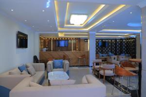 a living room with white couches and a bar at Libanos Hotel in Mekʼelē