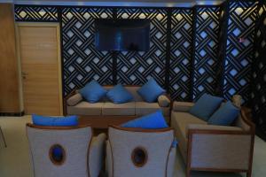 a living room with a couch and blue pillows at Libanos Hotel in Mekʼelē