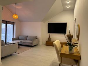 a living room with a couch and a tv on the wall at Boutique apartment Sky Nest in Uman