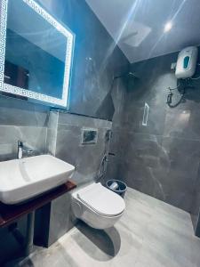 a bathroom with a white toilet and a sink at Ram Anandam inn in Ayodhya +16 photos