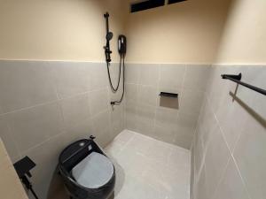 a bathroom with a toilet and a phone on the wall at Homey Bamboo Lanta in Ban Ai Dao