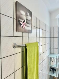 a bathroom with a green towel and rocks on the wall at VAJAGIC 1 - Apartment 4 Pers, 60 qm, EG, Messe, Uni Klinik in Essen +11 photos