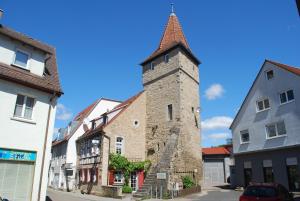 an old building with a tower on a street at Tauber Lodge in Creglingen