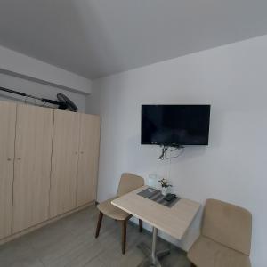 a room with a table and chairs and a tv on the wall at Andromachi Apartments in Jembke