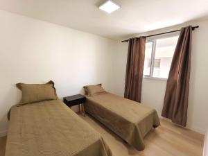 a bedroom with two beds and a window at bauer in Camboriú