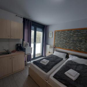 a bedroom with two beds and a kitchen with a window at Andromachi Apartments in Jembke +42 photos
